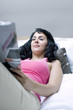 Woman reading magazine on the bed