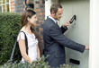 Businessman knocking on the door while businesswoman waits by the side