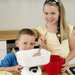 Boy and girl smiling at the camera while baking in the kitchen