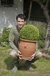 Man lifting up a pot of plant