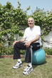 Senior man sitting on fitness ball