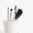 A set of cosmetic applicators in a cup