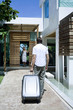 Man with his briefcase walking towards woman standing at the doorway