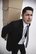 Businessman carrying stacked boxes on his back
