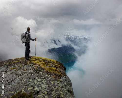 Photo: Man with hiking equipment standing on rock's edge Man with hiking equipment standing on rock's edge