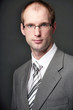 Portrait of businessman wearing a grey suit and black white tie