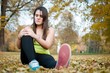 Knee injury - woman sitting in pain