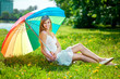 Smiling woman with a rainbow umbrella outdoors