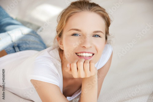 Foto: smiling teenage girl on a bed smiling teenage girl on a bed