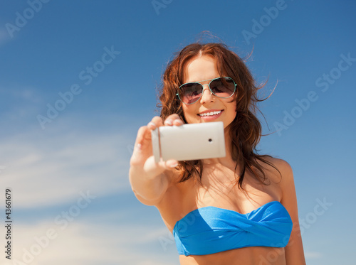 Photo: happy woman with phone on the beach happy woman with phone on the beach