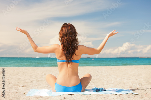 Photo: woman practicing yoga lotus pose on the beach woman practicing yoga lotus pose on the beach