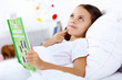 Foto: Girl with a book in bed at home Girl with a book in bed at home