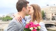 Portrait of romantic man giving flowers to woman