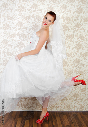 Foto: Portrait of young beautiful bride in shoes Portrait of young beautiful bride in shoes
