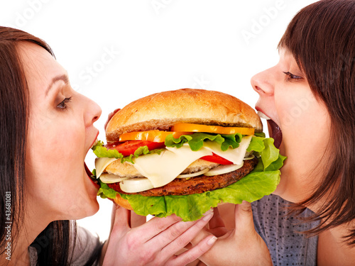 Photo: Women eating hamburger. Women eating hamburger.