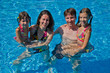 Happy family with two kids in swimming pool. Summer vacation