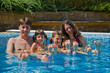 Happy family with  two kids in swimming pool. Summer vacation