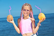Little girl with fruit on the beach
