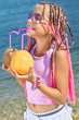 Photo: Little girl with fruit on the beach Little girl with fruit on the beach