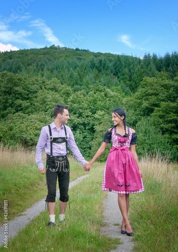 Foto: Fröhliches Bayerisches Paar mit Lederhosen und Dirndl Fröhliches Bayerisches Paar mit Lederhosen und Dirndl