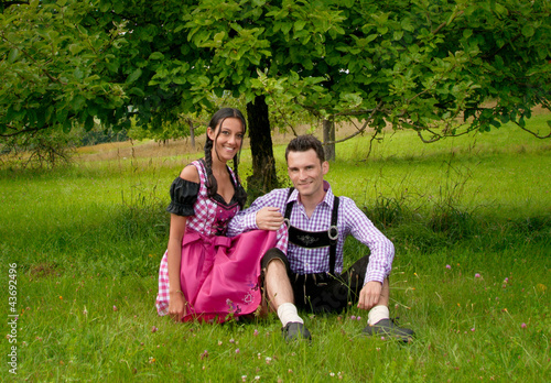 Foto: Fröhliches Bayerisches Paar mit Lederhosen und Dirndl Fröhliches Bayerisches Paar mit Lederhosen und Dirndl