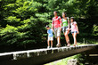 Photo: Family walking on a bridge in mountain forest Family walking on a bridge in mountain forest