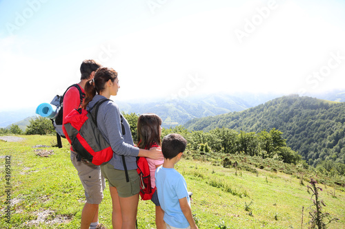 Foto: Family on a trek day in the mountain looking at the view Family on a trek day in the mountain looking at the view