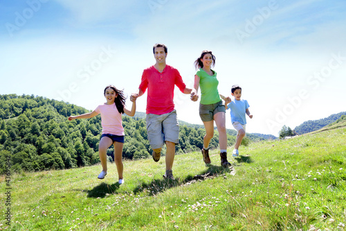 Photo: Happy family enjoying and running together in the mountains Happy family enjoying and running together in the mountains