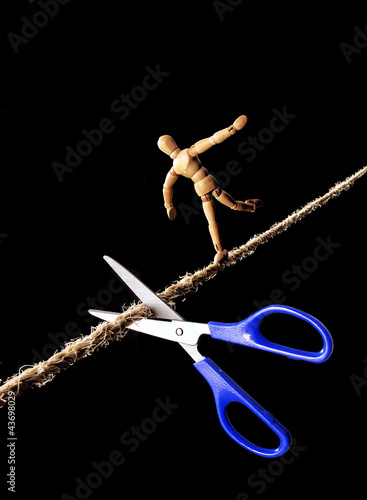 Photo: Tijera cortando la cuerda de un equilibrista. Tijera cortando la cuerda de un equilibrista.