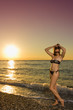 Ragazza in riva al mare si tocca i capelli