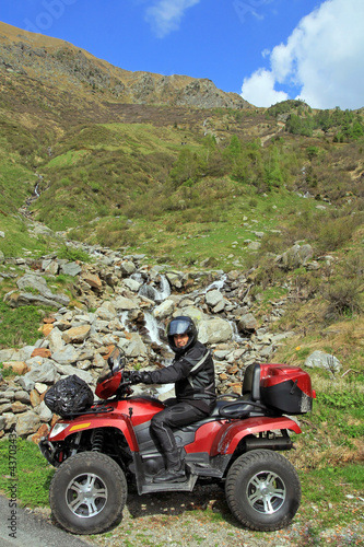 Photo: Mit dem ATV vor dem Wasserfall in den Bergen Mit dem ATV vor dem Wasserfall in den Bergen