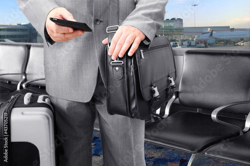 Photo: Traveling Businessman Calling by Phone at the airport Traveling Businessman Calling by Phone at the airport