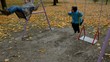 Two boys swinging on playground in autumn
