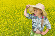 Foto: The little girl in the hat among the blossoming of the field. The little girl in the hat among the blossoming of the field.