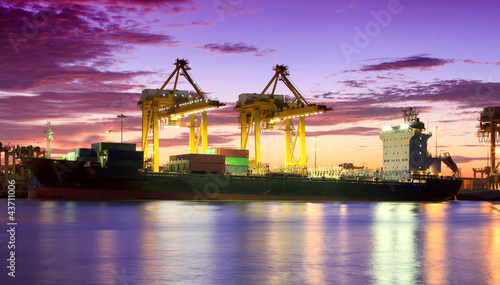 Photo: Container Cargo freight ship with working crane bridge in shipya Container Cargo freight ship with working crane bridge in shipya