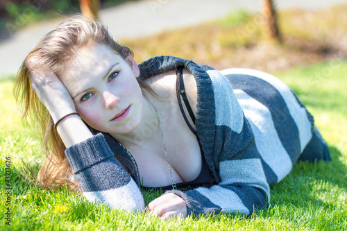 Photo: Attractive young caucasian female lies on grass Attractive young caucasian female lies on grass