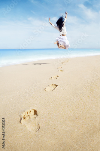 Photo: Woman with footprint enjoying freedom on beach Woman with footprint enjoying freedom on beach