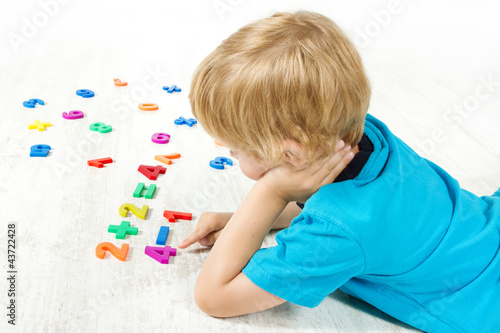 Photo: Child solve the mathematics example. Looking for answer. Child solve the mathematics example. Looking for answer.