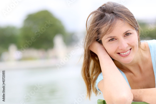 Photo: Portrait of beautiful woman sitting in park Portrait of beautiful woman sitting in park