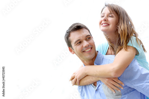 Photo: Man carrying girlfriend on his back, isolated Man carrying girlfriend on his back, isolated