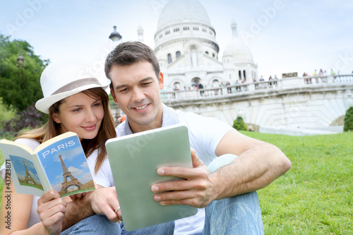Photo: Couple using tablet in front of Sacre Coeur Basilica Couple using tablet in front of Sacre Coeur Basilica