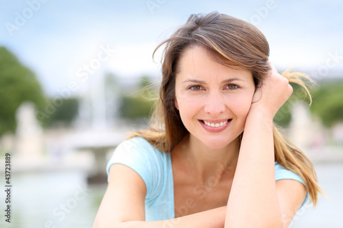Photo: Portrait of beautiful woman sitting in park Portrait of beautiful woman sitting in park
