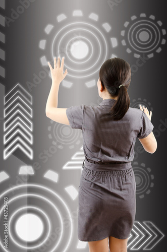 Photo: Business lady pushing digital button on touch screen interface. Business lady pushing digital button on touch screen interface.