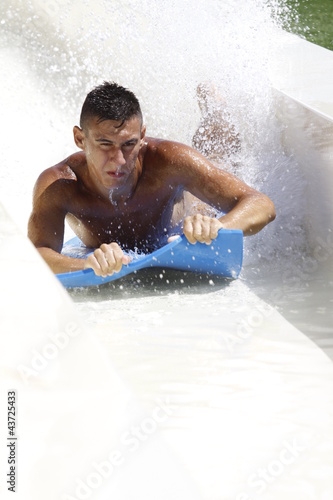 Photo: ragazzo sullo scivolo acquatico ragazzo sullo scivolo acquatico