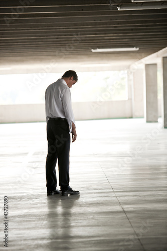 Photo: Depressed Businessman In Undeground Parking Depressed Businessman In Undeground Parking
