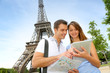 Photo: Tourists using electronic tablet in front of the Eiffel tower Tourists using electronic tablet in front of the Eiffel tower