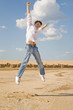 Young man jumping in the air against a blue sky