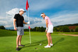 Junges sportliches Paar beim Golfen am Golfplatz