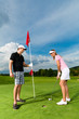 Junges sportliches Paar beim Golfen am Golfplatz
