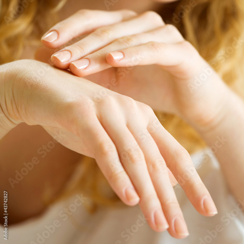 Foto: Closeup of woman hands applying cream Closeup of woman hands applying cream